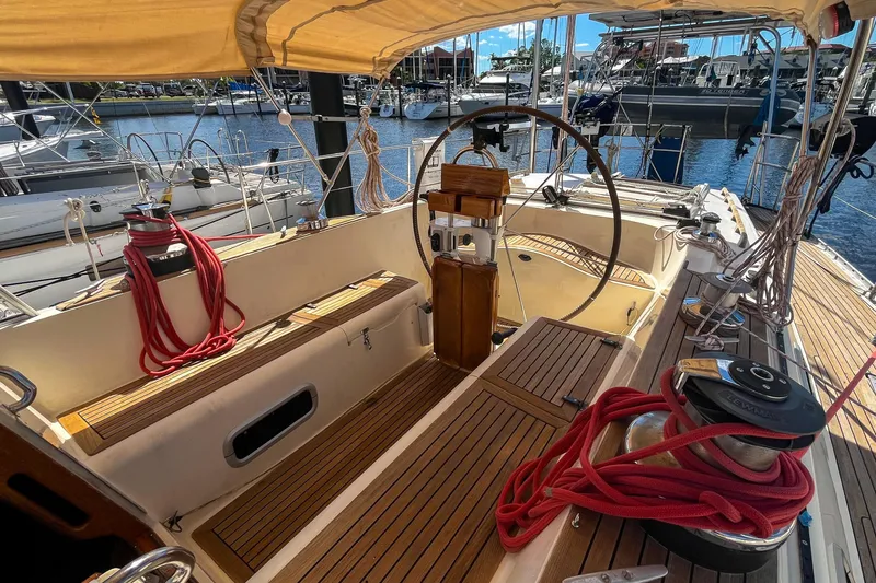Slide: The Image of Cockpit of 1991 Oyster LW48 sailboat with wooden deck and red ropes in marina. - 40