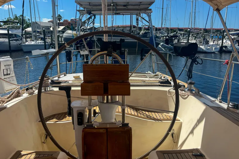 Slide: The Image of Cockpit view of 1991 Oyster LW48 yacht docked at marina, featuring steering wheel and equipment. - 42