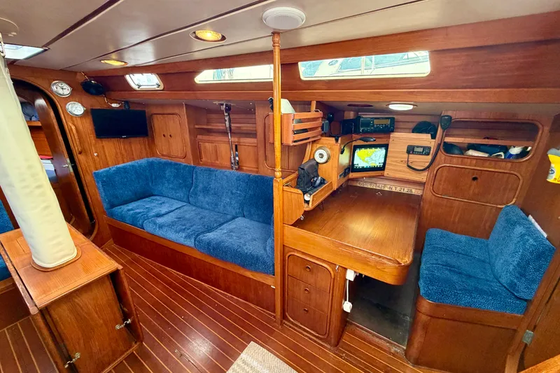 Slide: The Image of Cozy interior of 1991 Oyster Lightwave 48 yacht with blue seating and navigation equipment. - 5