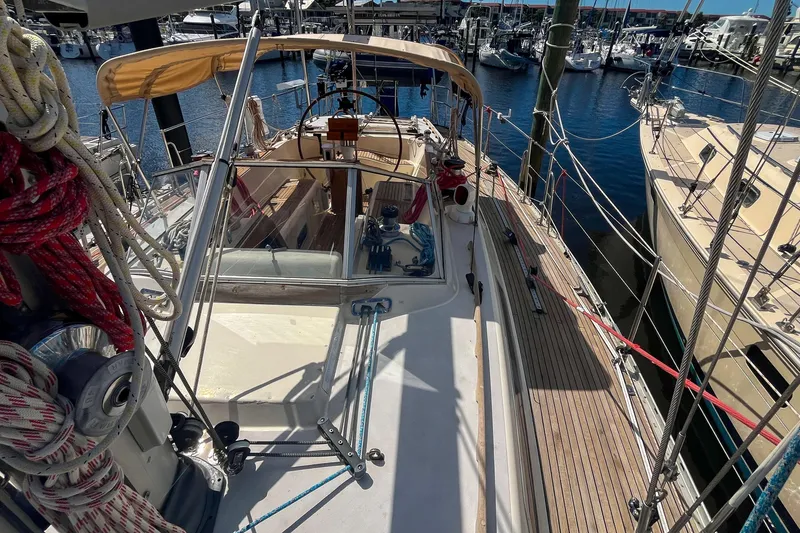 Slide: The Image of Sailboat deck view of 1991 Oyster LW48, docked in a marina with clear skies. - 57