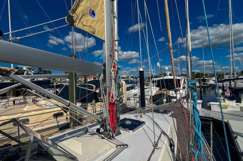 Slide: The Image of Sailboat deck view of 1991 Oyster LW48 in marina, under clear blue sky. - 58
