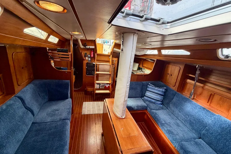 Slide: The Image of Interior of 1991 Oyster Lightwave 48 yacht with blue seating and wooden finishes. - 6
