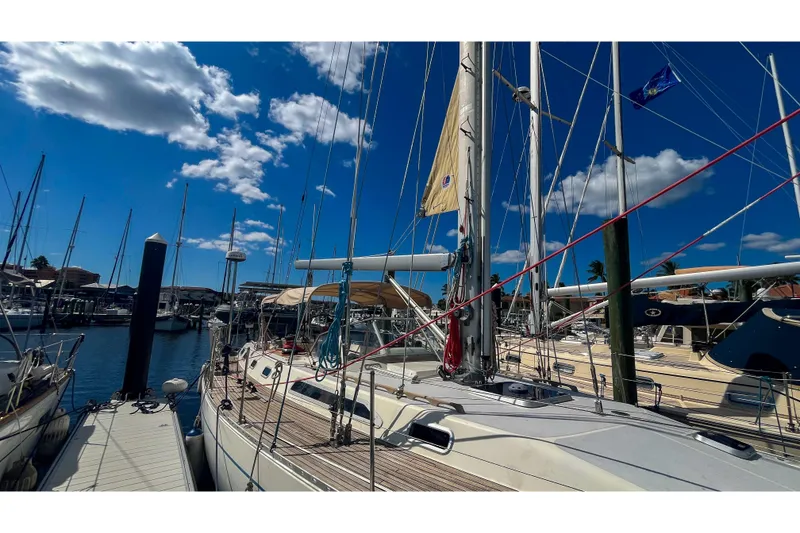 Slide: The Image of Sailboats docked at marina under blue sky, featuring 1991 Oyster LW48 yacht. - 63
