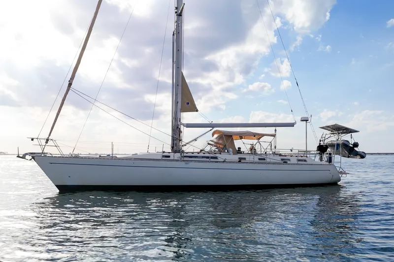 Slide: The Image of Sailboat Oyster Lightwave 48, 1991 model, on calm waters under a partly cloudy sky. - 72