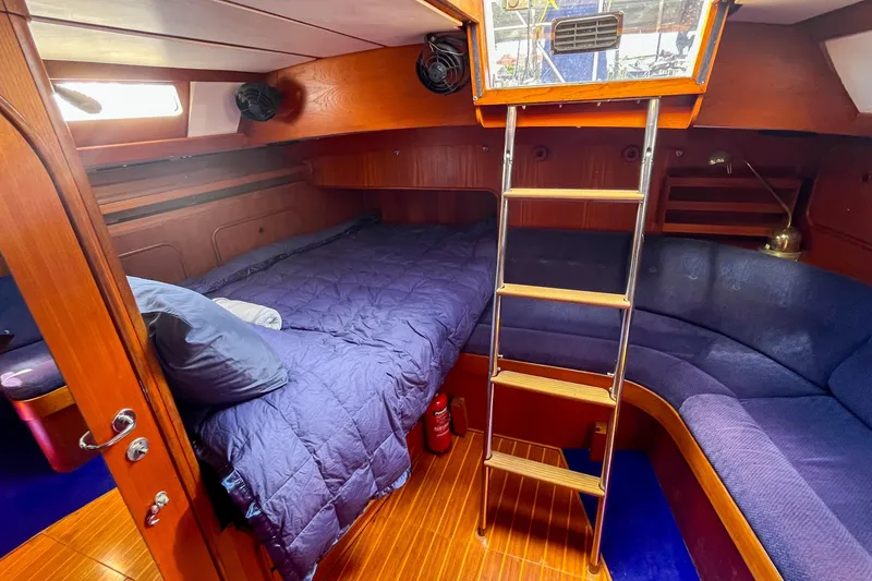 Slide: The Image of Cozy cabin interior of 1991 Oyster LW48 yacht with wooden finish and blue bedding. - 8