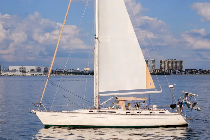 Slide: The Image of Sailboat Oyster Lightwave 48, 1991 model, cruising on calm waters with cityscape background. - 81