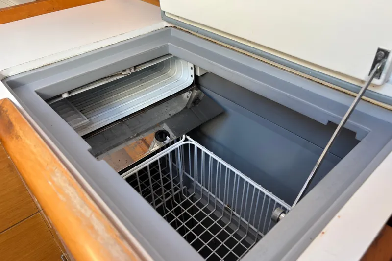 Slide: The Image of Open refrigerator compartment on 2018 Jeanneau Sun Odyssey 389 sailboat, featuring storage basket. - 9