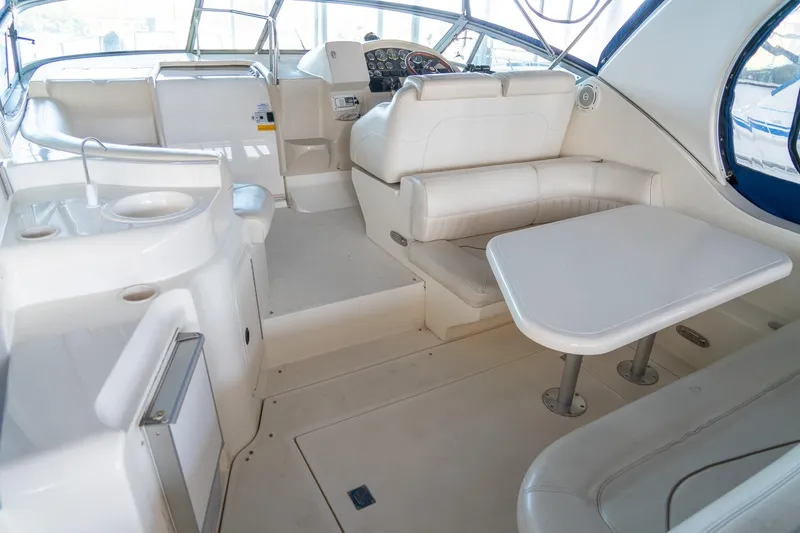 Slide: The Image of 2000 Cruisers Yachts 3375 Express interior with white seating and table, modern helm. - 10