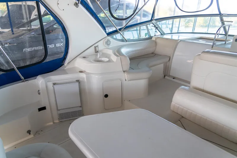 Slide: The Image of 2000 Cruisers Yachts 3375 Express interior with white seating and compact kitchenette. - 12