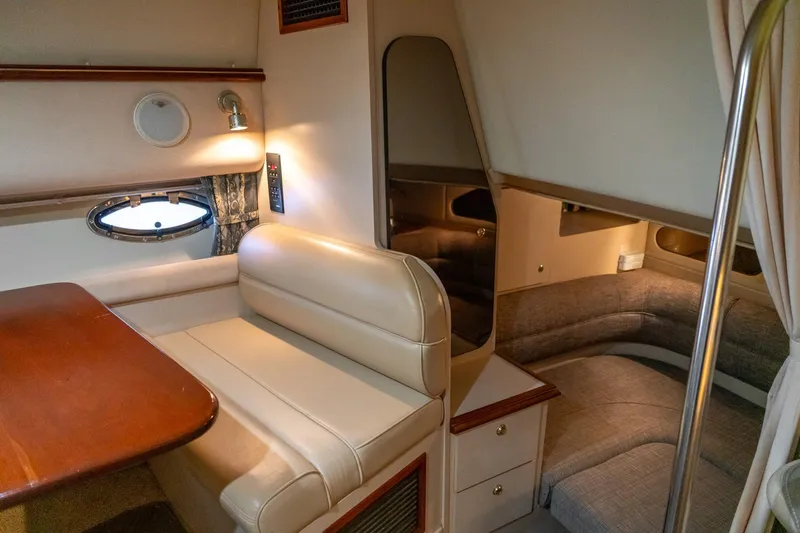 Slide: The Image of Interior of 2000 Cruisers Yachts 3375 Express, featuring cozy seating and elegant wood finishes. - 23