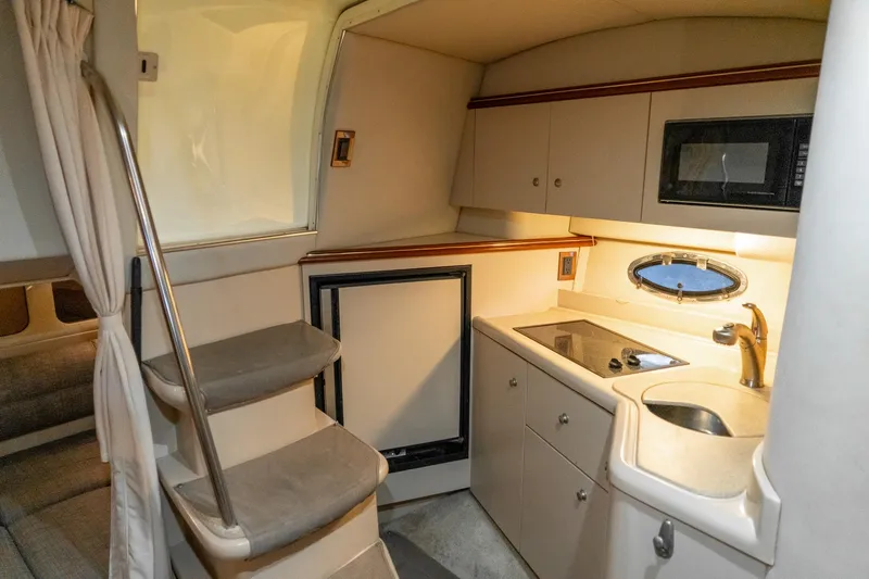 Slide: The Image of 2000 Cruisers Yachts 3375 Express interior kitchen with stove, sink, and microwave. - 28