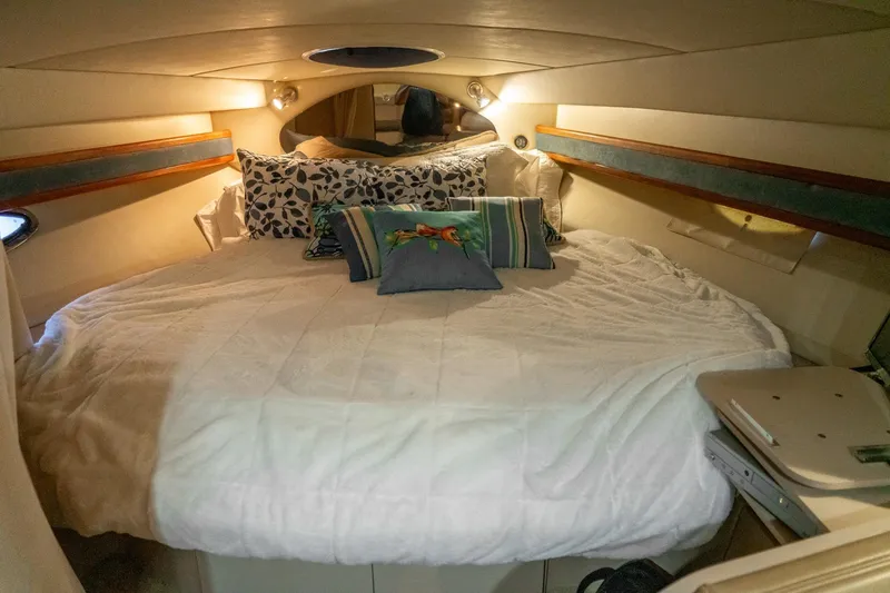 Slide: The Image of Cozy cabin interior of 2000 Cruisers Yachts 3375 Express with plush bedding and ambient lighting. - 29