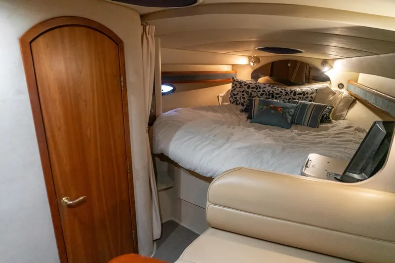 Slide: The Image of Cozy cabin interior of 2000 Cruisers Yachts 3375 Express with plush bedding and wooden door. - 31