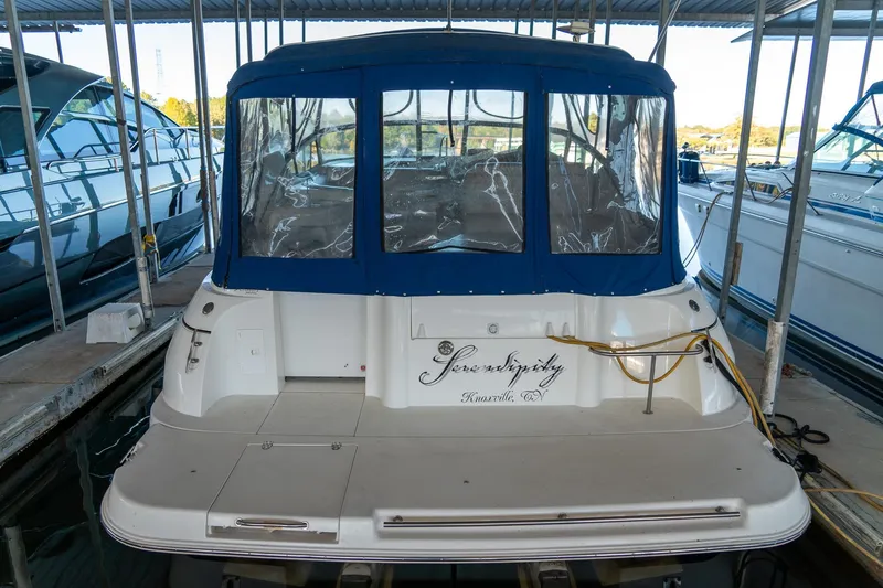 Slide: The Image of 2000 Cruisers Yachts 3375 Express docked, featuring blue canopy and white hull. - 9