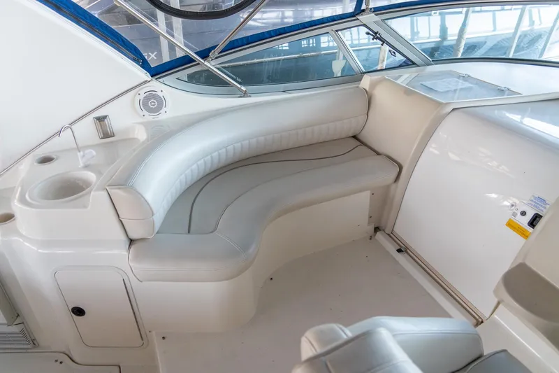 Slide: The Image of 2000 Cruisers Yachts 3375 Express interior with white seating and built-in cup holder. - 13