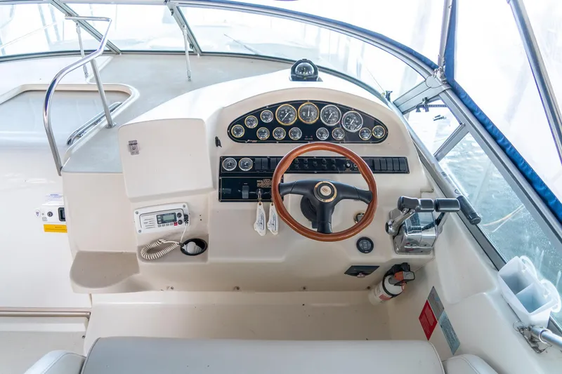 Slide: The Image of 2000 Cruisers Yachts 3375 Express helm with gauges, steering wheel, and controls. - 16