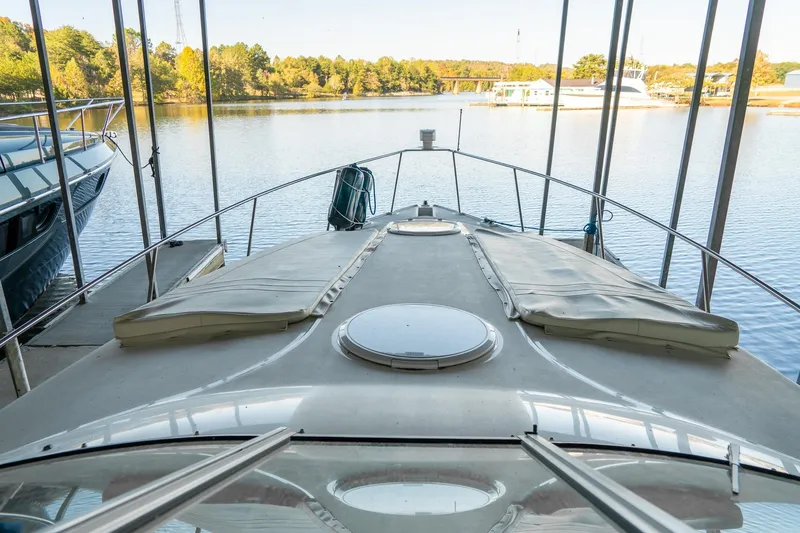 Slide: The Image of 2000 Cruisers Yachts 3375 Express docked, overlooking serene lake and lush trees. - 20