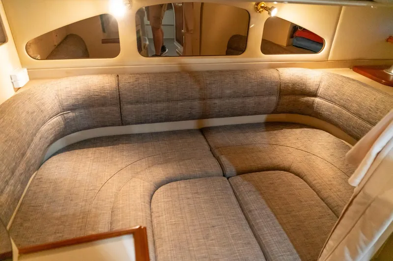 Slide: The Image of Interior of 2000 Cruisers Yachts 3375 Express, featuring a cozy, upholstered seating area. - 25