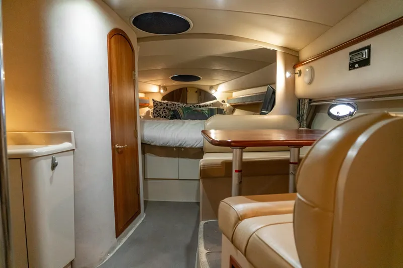 Slide: The Image of 2000 Cruisers Yachts 3375 Express cabin interior with seating, table, and bed. - 26