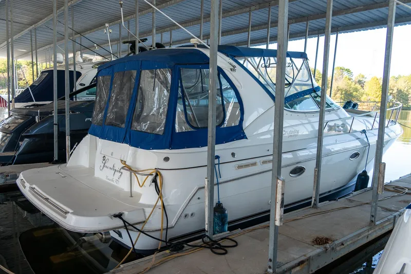 Slide: The Image of 2000 Cruisers Yachts 3375 Express docked in a marina with blue canopy. - 8