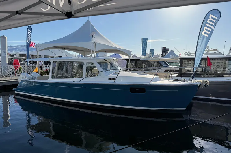 The Image of 2026 MJM 38R boat on trailer, parked near palm trees. - 0