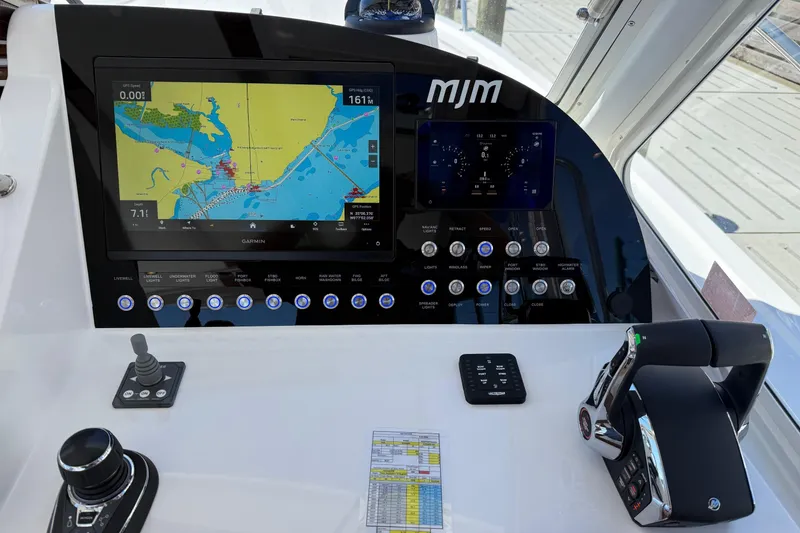 Slide: The Image of 2026 MJM 38R boat with Mercury outboard motor, parked near palm trees. - 1