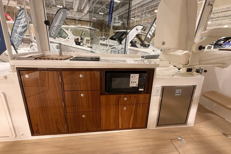 Slide: The Image of 2026 MJM 38R yacht interior with wooden cabinetry, microwave, and modern amenities. - 15