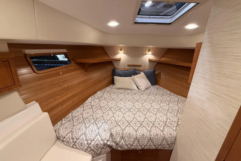 Slide: The Image of Cozy cabin interior of 2026 MJM 38R yacht with wood paneling and skylight. - 26