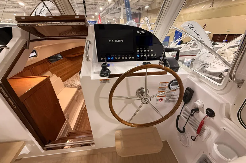 Slide: The Image of Interior view of 2026 MJM 38R boat cockpit with Garmin navigation system and wooden steering wheel. - 35