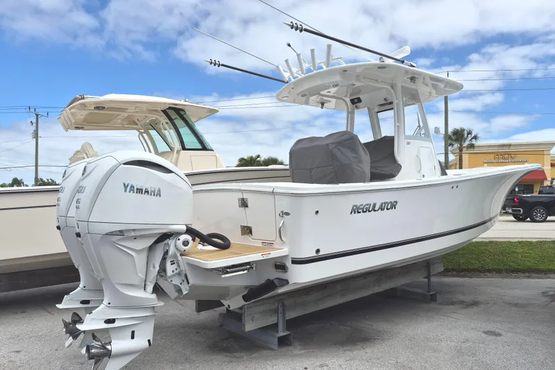 Slide: The Image of 2026 Regulator 28 boat with Yamaha engines, displayed outdoors on a sunny day. - 14