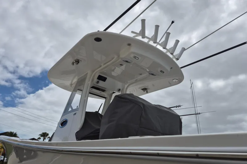 Slide: The Image of 2026 Regulator 28 boat with T-top and rod holders under cloudy sky. - 16