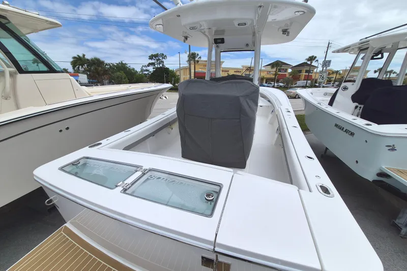 Slide: The Image of 2026 Regulator 28 boat with covered console, docked alongside similar vessels. - 18