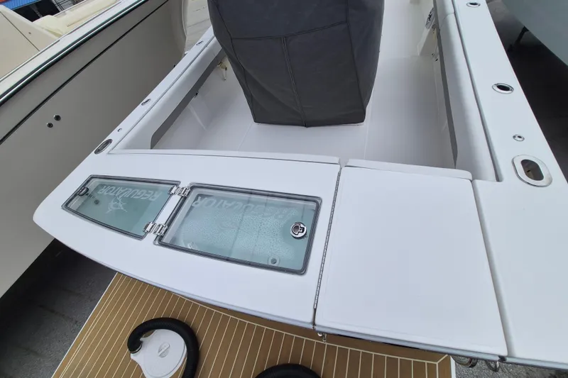 Slide: The Image of 2026 Regulator 28 boat deck with storage compartments and seating area. - 19