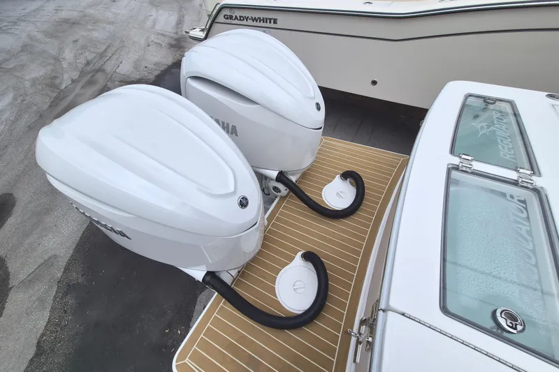 Slide: The Image of Twin Yamaha outboard engines on a 2026 Regulator 28 boat, docked beside another vessel. - 23