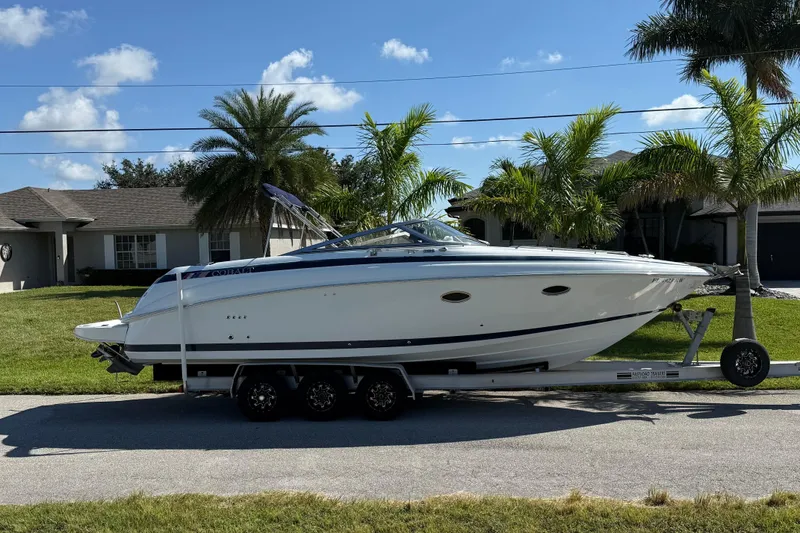 The Image of 1999 Cobalt 293 boat cruising on a river with lush green trees in the background. - 0