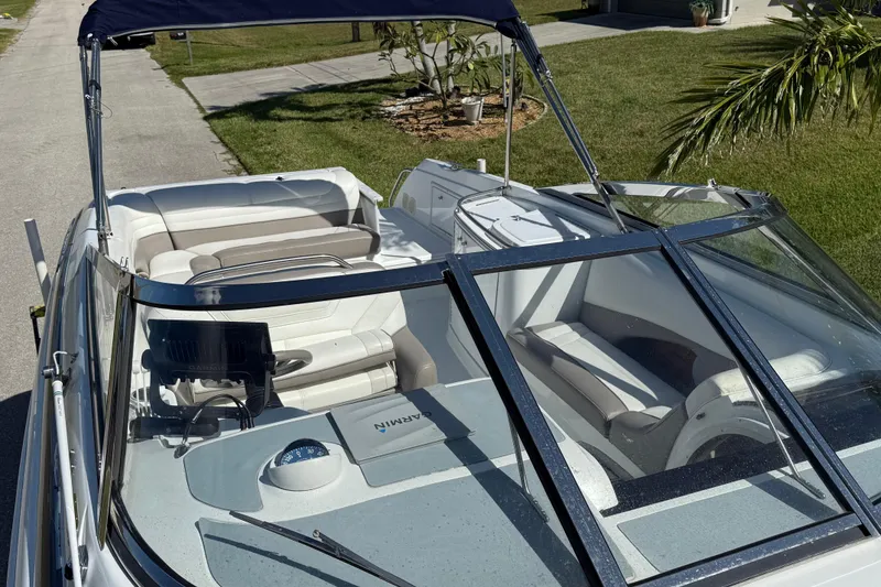 Slide: The Image of 1999 Cobalt 293 boat with open cockpit and windshield, parked on a driveway. - 16