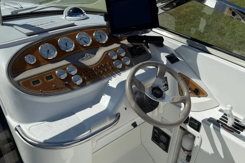 Slide: The Image of 1999 Cobalt 293 boat interior with white and beige seating, steering wheel, and console. - 19