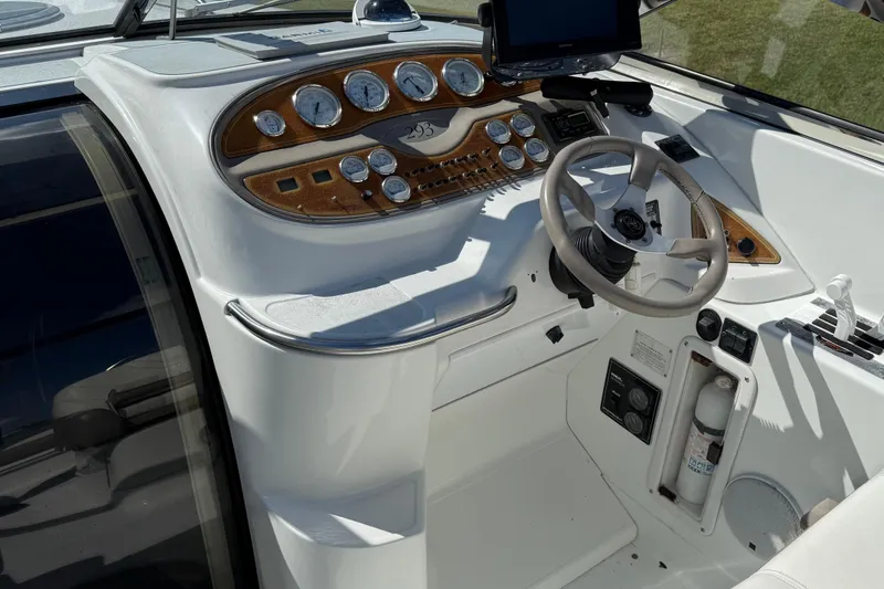 Slide: The Image of 1999 Cobalt 293 boat with white seating and Garmin navigation, parked on a sunny street. - 20