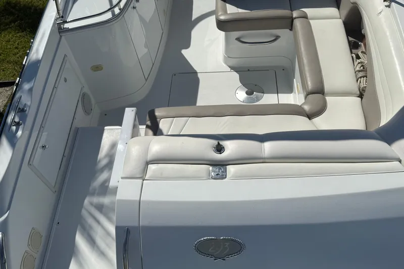 Slide: The Image of 1999 Cobalt 293 boat interior with white and gray seating, docked on a sunny day. - 27