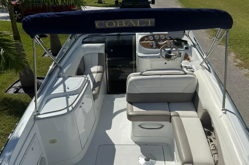 Slide: The Image of 1999 Cobalt 293 boat interior with white and gray seating, steering wheel, and control panel. - 28