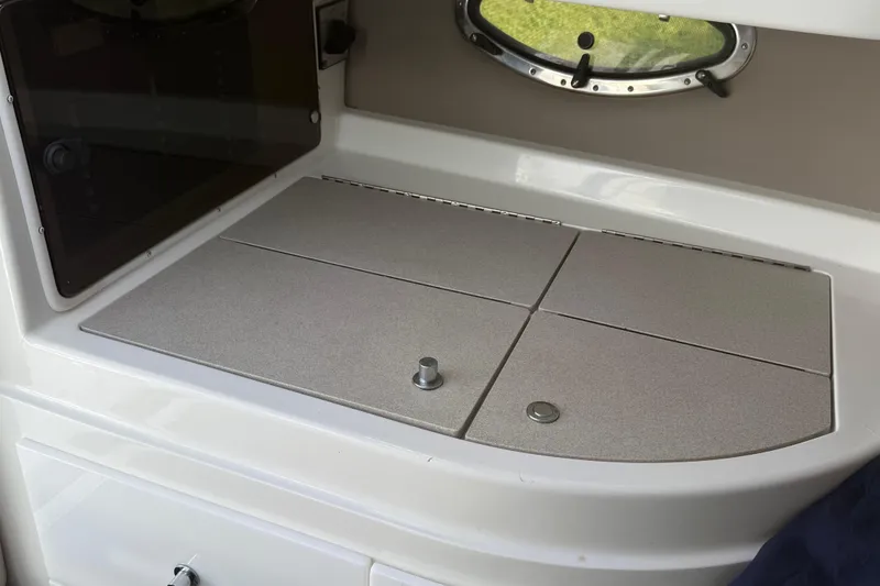 Slide: The Image of Open storage compartment in 1999 Cobalt 293 boat, showing interior wiring and carpeted edges. - 47