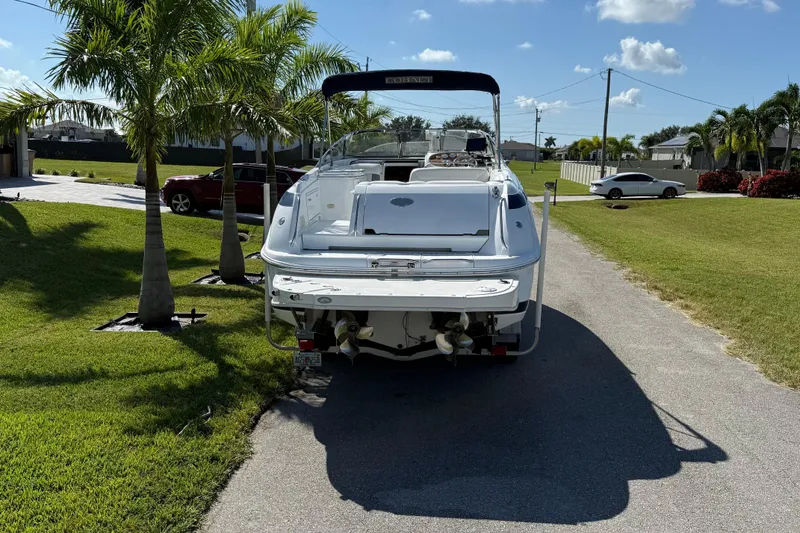 Slide: The Image of 1999 Cobalt 293 boat on trailer, parked near palm trees and residential area. - 6