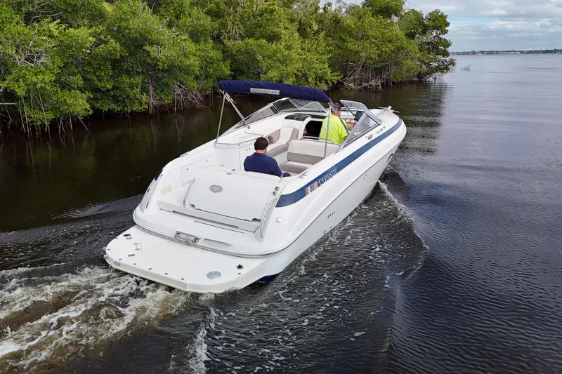 Slide: The Image of Aerial view of a 1999 Cobalt 293 boat navigating a narrow waterway surrounded by lush greenery. - 77