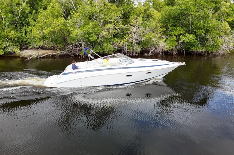 Slide: The Image of A 1999 Cobalt 293 boat cruising through a narrow, tree-lined waterway. - 78