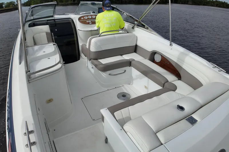 Slide: The Image of 1999 Cobalt 293 boat interior with white seating and a person at the helm. - 87