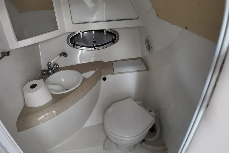 Slide: The Image of Compact bathroom in a 1999 Cobalt 293 boat with sink, toilet, and porthole. - 92
