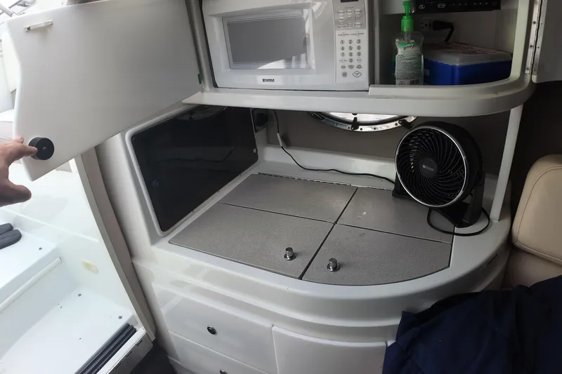 Slide: The Image of Interior of a 1999 Cobalt 293 boat with microwave, fan, and storage. - 93
