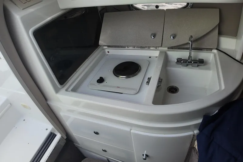 Slide: The Image of Compact kitchen area in a 1999 Cobalt 293 boat with stove and sink. - 94