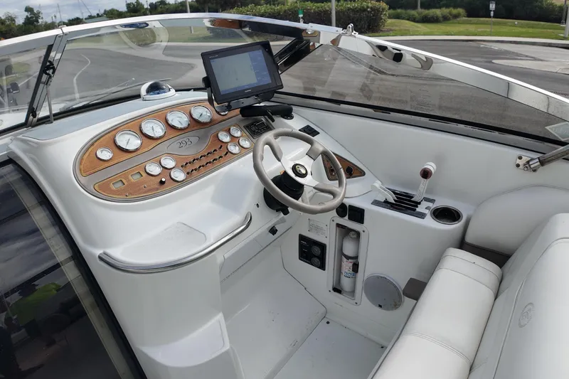 Slide: The Image of 1999 Cobalt 293 boat dashboard with steering wheel and navigation instruments. - 95