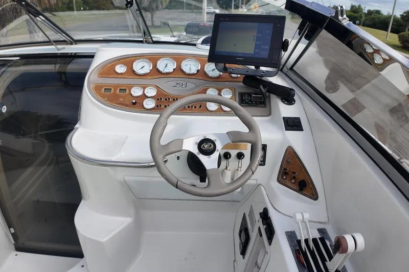 Slide: The Image of Cockpit of a 1999 Cobalt 293 boat with steering wheel and navigation controls. - 97